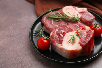 Pieces of raw beef, rosemary and tomatoes on brown textured table, closeup. Space for text