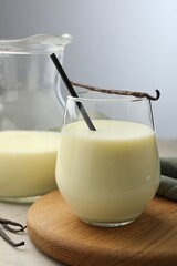 Delicious vanilla milk and pods on grey table