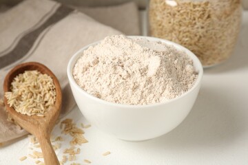 Brown rice and flour on white table, closeup