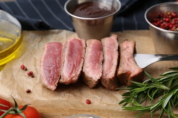 Delicious sliced beef tenderloin with different degrees of doneness, sauce and spices on table, closeup