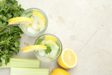 Healthy drink with parsley, lemons and celery on light grey table, flat lay. Space for text