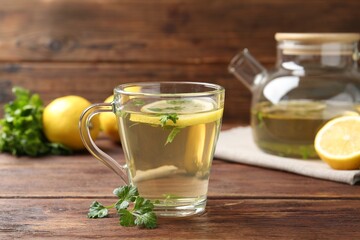 Healthy parsley tea with lemon slices on wooden table. Detox drink
