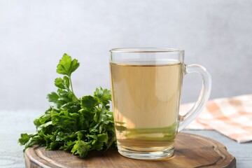 Healthy parsley tea on grey wooden table, closeup. Detox drink
