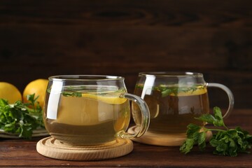 Healthy parsley tea with lemon slices on wooden table, space for text. Detox drink