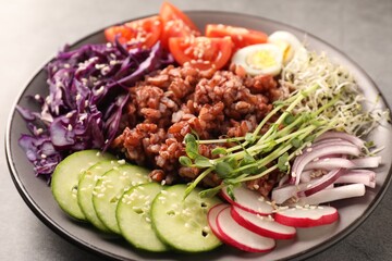 Tasty salad with brown rice on grey table, closeup