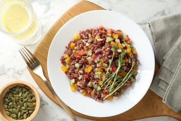 Tasty salad with brown rice served on white marble table, flat lay