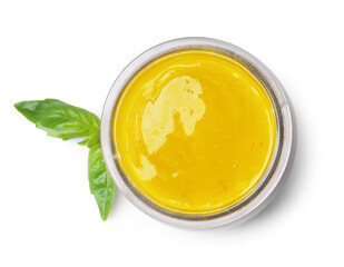 Tasty curry sauce in glass jar and basil isolated on white, top view