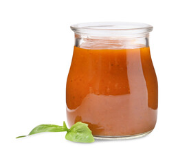 Tasty curry sauce in glass jar and basil isolated on white