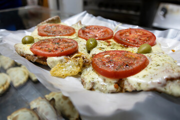 A typical dish of Argentine cuisine called Milanesa Napolitana, it looks like a pizza but consists of beef fillets covered with tomato sauce, cheese, sliced ​​tomatoes and olives