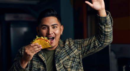 Young hispanic male excitedly holding a tasty taco in casual setting