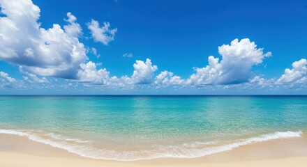 Fototapeta premium A scenic view of a tropical beach with white sand, turquoise water, and a blue sky with clouds