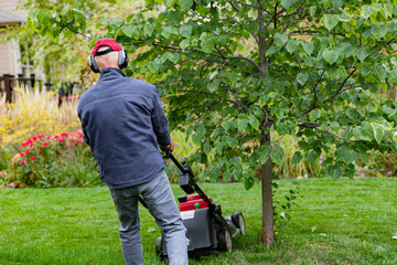 Caucasian elderly Man using a Hearing Protection Device, HPD, ear muffs, to prevent cumulative damage which can lead to hearing loss and or dementia.