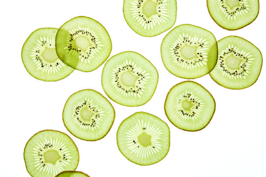 Vibrant kiwi slices on light background create fresh pattern