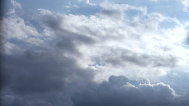Accelerated horizontal 4k video of gray clouds in a bright blue sky during daytime in Mexico.