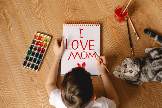 Child Painting Mother&rsquo;s Day Card with Cat Watching Nearby