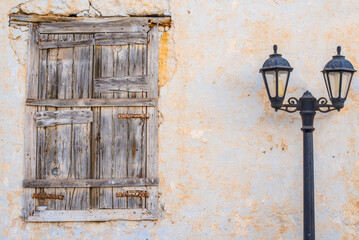 Rustic charm of an aged window and lamp post in Triovasalos