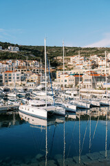 Yachts off the coast of Lustica Bay near colorful houses. Montenegro
