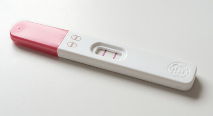 A close up of a positive pregnancy test with two pink lines 