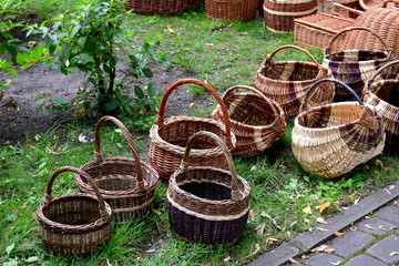 A view of a set of wicker baskets with sturdy handles displayed for purchase on a vast lawn, meadow...