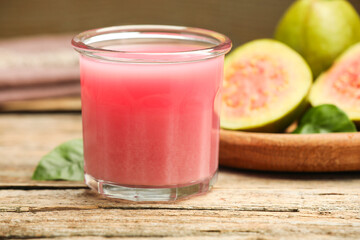 Refreshing guava juice and fresh fruits on wooden table, closeup
