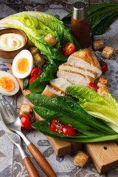 Fresh Caesar salad ingredients displayed on a wooden board