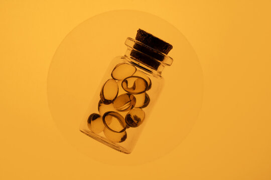 Colorful omega-3 and vitamin D capsules in a glass jar