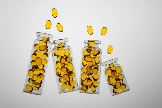 Omega-3 and Vitamin D colorful capsules in transparent bottles