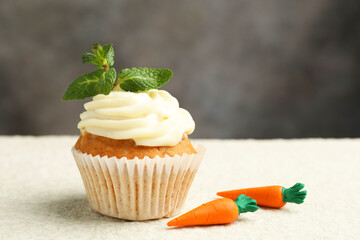 Delicious carrot cupcake with mint on light textured table, closeup