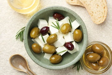 Tasty olives served with feta cheese, oil and bread on table, flat lay