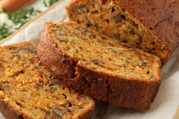 Cut homemade carrot cake with nuts on table, closeup