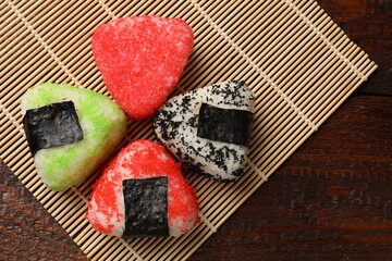 Tasty tobiko onigiri (Japanese rice balls) served on wooden table, top view