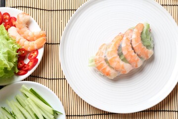 Spring roll. Rice paper sheet with different ingredients on bamboo mat, flat lay