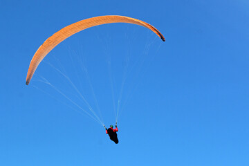 Paraglider flying in a blue sky	