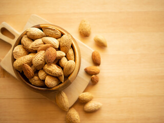 Raw organic whole almonds in a wooden bowl