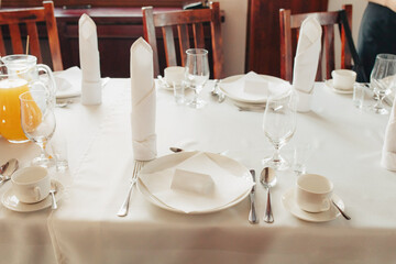 Close-up of birthday party table setting – white tablecloth, elegant decor for a festive celebration