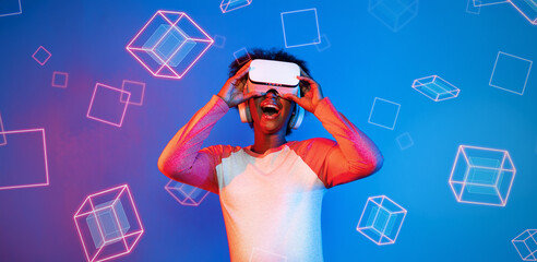 African girl with VR glasses standing at blue and pink background and looking at floating geometric...