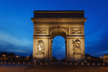 The Arc de Triomphe in Paris is lit up at night