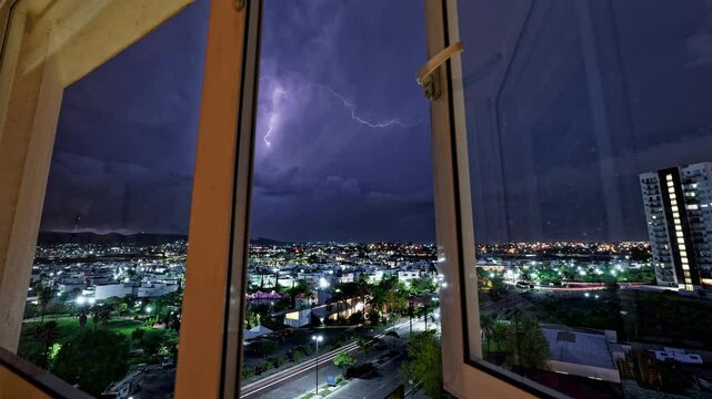 Horizontal landscaped video of Puebla cityscape with purple lightnings during nighttime