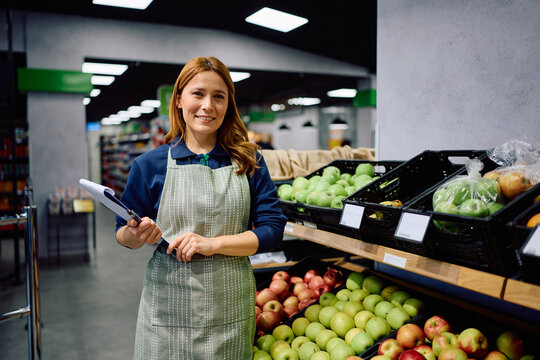 Happy female grocery store worker looking at camera. - Powered by Adobe