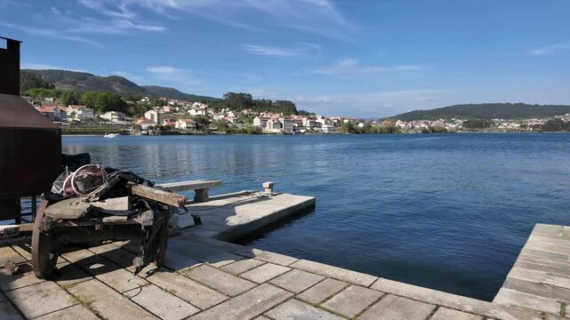 Traditional galician granaries, known as horreos, stand on stilts by the water's edge, topped with stone crosses in combarro, spain