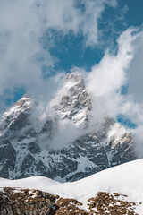 The iconic Matterhorn rises sharply against a bright blue sky, with snow covered slopes and rocky terrain near Zermatt, Switzerland.
