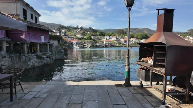 Traditional galician granaries, known as horreos, stand on stilts by the water's edge, topped with stone crosses in combarro, spain