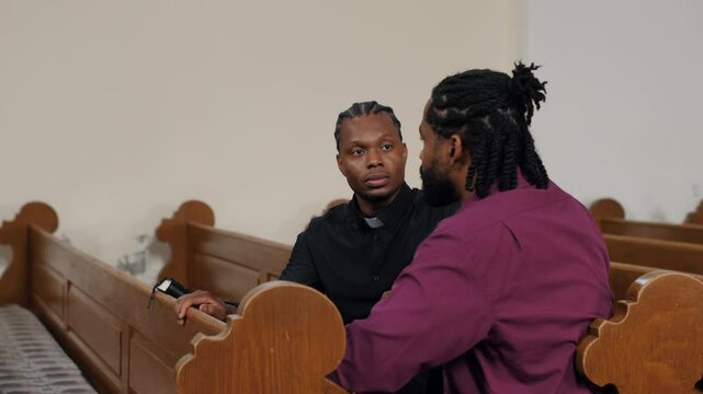 Priest comforting parishioner in church