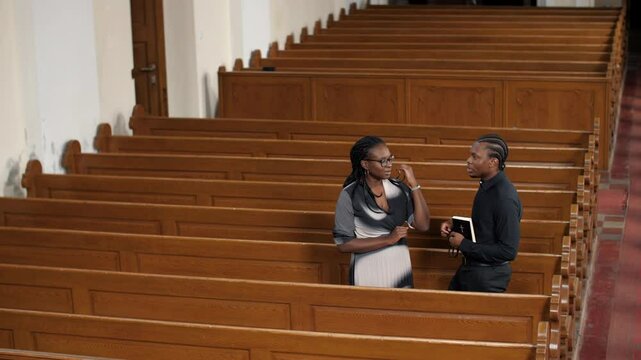 Pastor discussing with parishioner in church