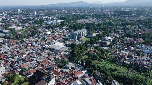 High-resolution 4K aerial drone footage showcasing a densely packed urban neighborhood featuring predominantly low-rise residential houses, scattered with a few modern mid-rise buildings