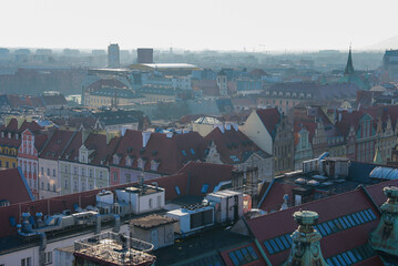 A view of Wroclaw, Poland, featuring historic gabled buildings with red tiled roofs, a church...