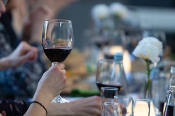 A glass of red wine in focus with a blurry background