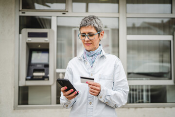 mature woman have online shopping on mobile phone with credit card