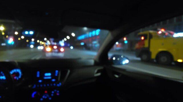 Night city view from inside car with blurred urban lights and illuminated dashboard, modern driving and urban mobility concept