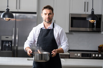 chef stirring a pot of aromatic soup with ladle. Chef cook in uniform cooking soup in the big...